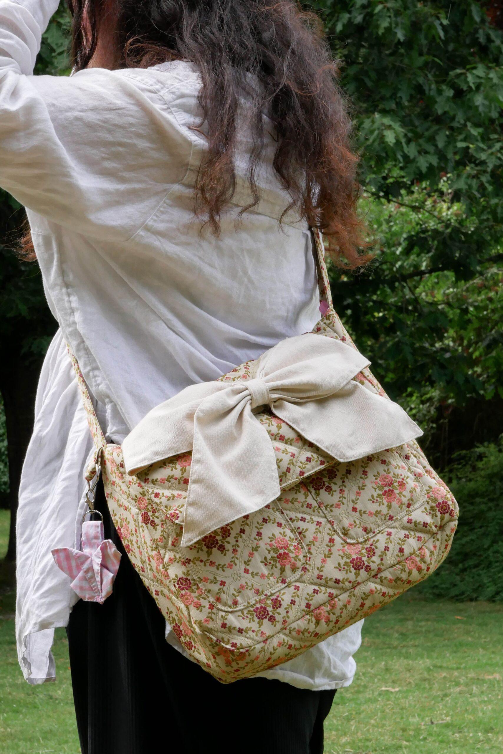 sac bandoulière tissé fleuri et rose, vert, crème bretagne nijichou
femme qui porte un sac bandoulière tissé fleuri et rose, vert avec un gros nœud