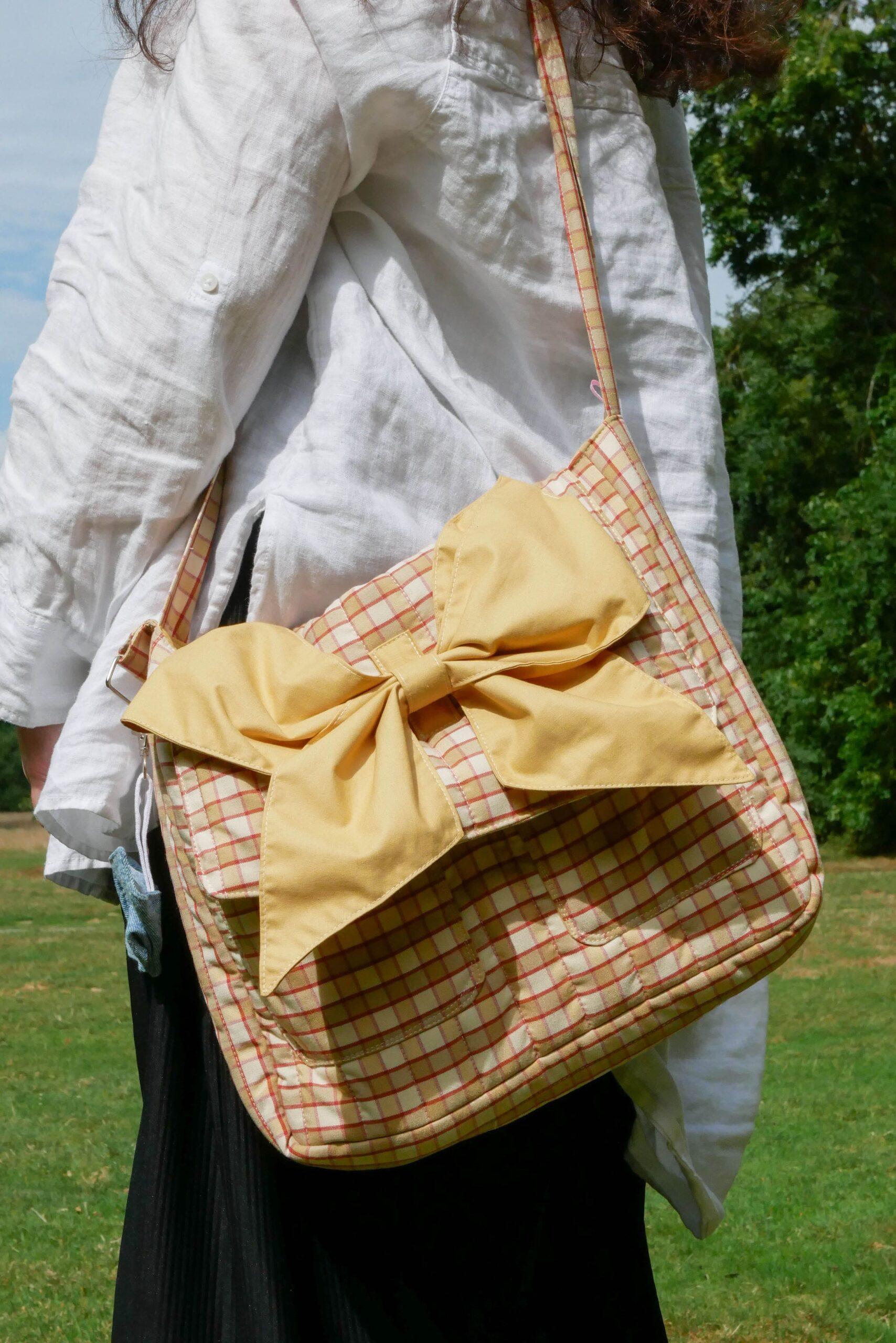 sac bandoulière beige à carreaux avec un nœud caramel bretagne nijichou
femme qui porte un sac bandoulière beige à carreaux avec un nœud caramel