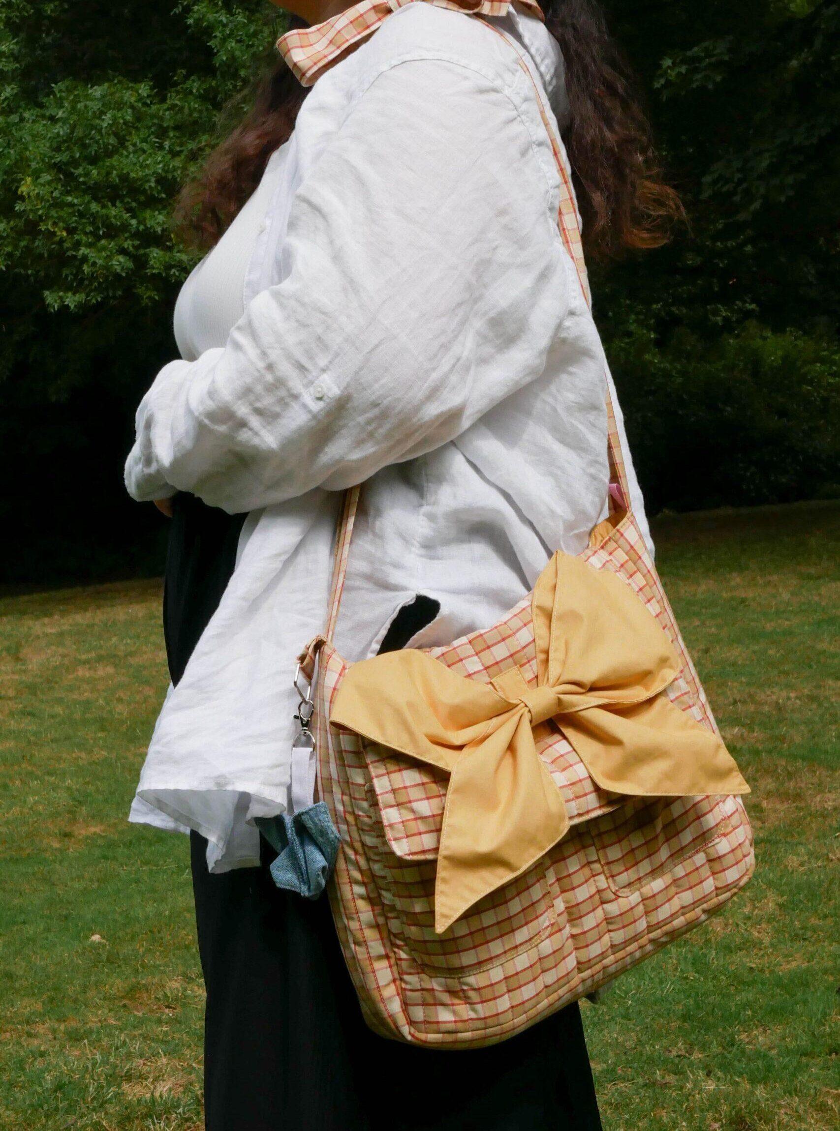 sac bandoulière beige à carreaux avec un nœud caramel bretagne nijichou
femme qui porte un sac bandoulière beige à carreaux avec un nœud caramel